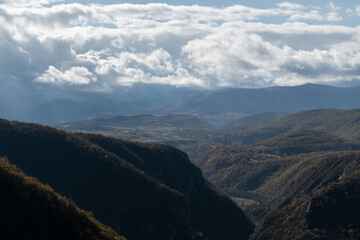 Unac river canyon toward Martin Brod against mountains and big bright clouds in distance, mountian landscape in autumn