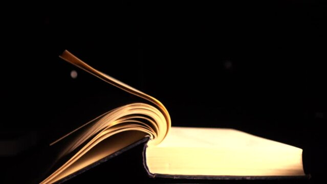 The pages of the book turn over by themselves. Slow-motion video of turning the page of an old book