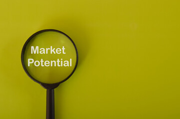 Magnifying glass written with MARKET potential isolated on a yellow background.