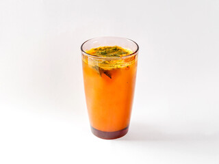Refreshing drink from sea buckthorn with mint in glass of colored glass on white background