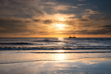 ship on horizon in sea at sunset