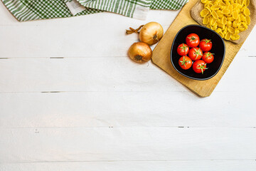 Pasta ingredients isolated. Cherry tomato, pasta, garlic and onions