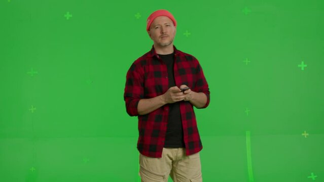 Man Wearing Casual Clothes Using Smartphone Standing On Green Screen Background