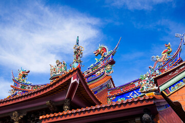 Obraz premium Ornate decoration on the roof of a Taiwanese temple building with the blue sky background