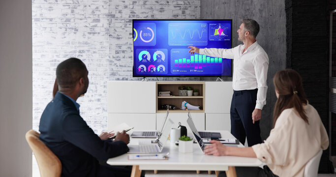 Businesspeople Looking At Businessman Giving Presentation