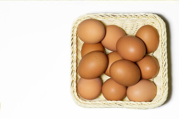 Overhead view of a basket full of eggs on a white background