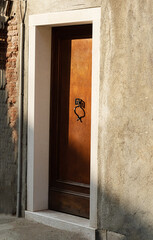 black forged handle on the front door of an unusual shape

