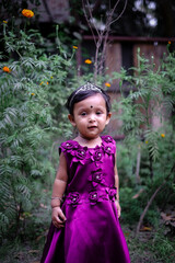 South asian little adorable cute girl on her first birthday, baby girl in princess dress, kid playing outside 