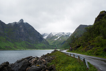 Scenic road along the fjords in Norway. Amazing landscape. Northern nature. Snow-capped mountains. Dramatic clouds. Travel, adventure