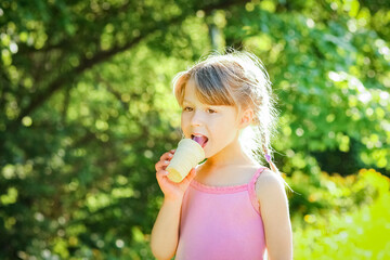 child eating ice cream in the park on the background
