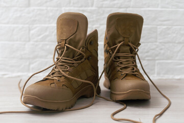 old brown military boots on a wooden table.