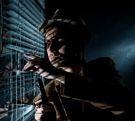 A private detective by the window with blinds, looking at the street,he is holding a gun in his...