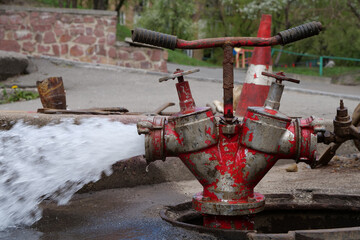 Water flows from faucet and pipe. Draining water from building plumbing system