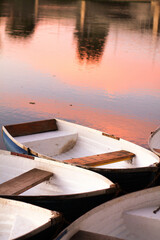 Fototapeta na wymiar Barcas pequeñas en un lago con una puesta de sol.