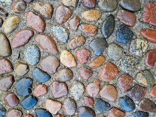 Stone pavement texture. Old cobblestone road top view. Pattern of brown stones
