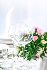 Simple and elegant wedding or festive table setting with flowers decoration on a white tablecloth.