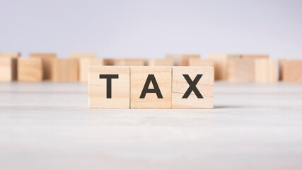 TAX - word concept written on wooden cubes or blocks on a light background