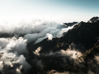 Shot from drone,a shot of pico grande, a landscape bathed in sunlight,majestic mountains under the clouds