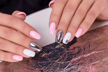 
Beautiful female hands with colourful manicure nails, pink and silver colored gel polish
