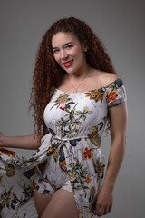 details of a latin woman with long curly hair, wears makeup and dress with print, beauty and casual fashion, female model