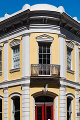 Obraz premium Beautiful yellow and white vintage building with an iron balcony