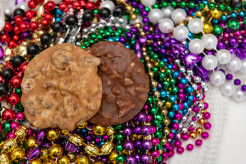 Pralines on top of colorful Mardi Gras beads background with a shallow depth of field