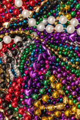 Many colorful mardi gras beads in a pile background