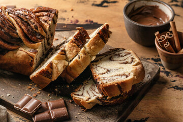 Chocolate Babka or Brioche Bread. Homemade sweet yeast pastry chocolate swirl bread sliced on wooden board.