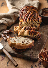Chocolate Babka or Brioche Bread. Homemade sweet yeast pastry chocolate swirl bread sliced on wooden rustic board