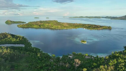 Early morning light shines on tropical islands and coral reefs in the Solomon Islands. This beautiful Melanesian country is home to extraordinary marine biodiversity and many historic WWII sites.