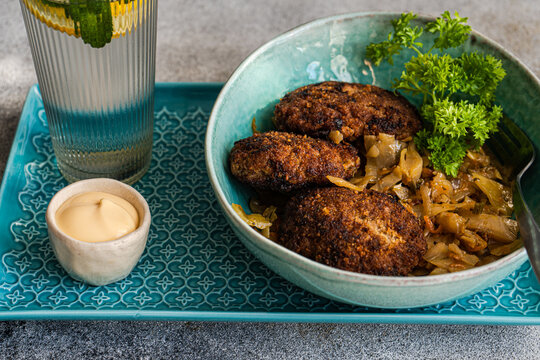 Pork cutlets with stewed cabbage, mayonnaise and a glass of mint lemon water