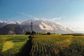 Field against the backdrop of mountains with clouds, Innsbruck, Austria