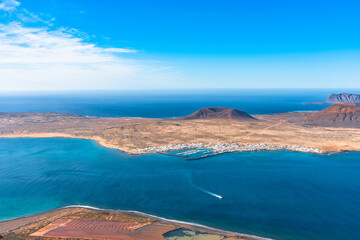 Panoramic aerial view of volcano cone at volcanic island La Graciosa in Atlantic ocean, from Mirador del Rio, Lanzarote, Canary Islands, Spain. Travel concept.