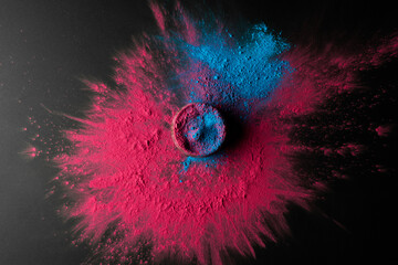High angle view of multi coloured powder and bowl with copy space on black background