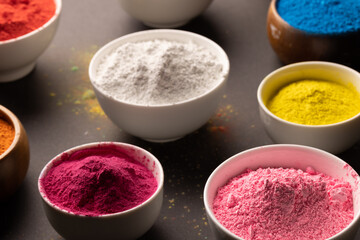 Close up of multi coloured powder in bowls and copy space
