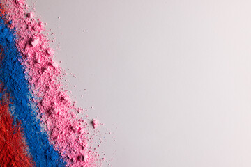 Close up of multi coloured powder with copy space on white background