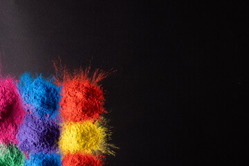 Close up of multi coloured powder and copy space on black background