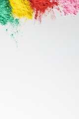 Fototapeta na wymiar Close up of multi coloured powder and copy space on white background
