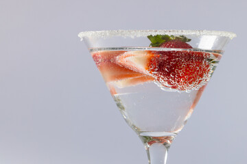 Glass with drink and fruits over grey background
