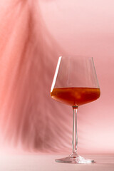 Vertical image of glasses with drink over pink background