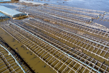 Aerial view of a farm flooded during the spring flood, greenhouses in the water