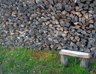 A wooden bench and stacked firewood.