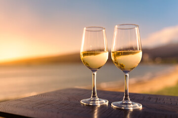 Romantic summertime lifestyle beach side getaway for two. Pair of wine glasses and tropical ocean...
