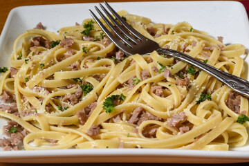 fettuccine  top with crumble sausage , parsley and cheese