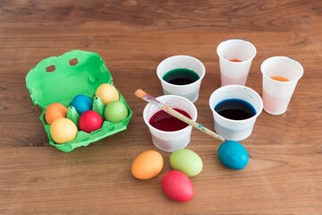 Coloring easter eggs with beautiful colors brush and paint cups. Handmade pastel easter egg for easternest at april. Decorative holidays present crafting time for traditional beautiful decoration
