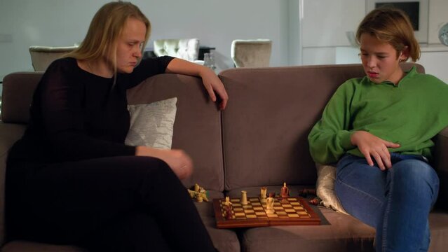 MS - Boy plays chess with his mother at home sitting on the sofa 5