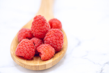 Ripe red Raspberries on a wooden spoon