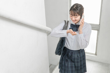 学校の校舎内・廊下・階段を歩く笑顔の高校生・中学生・女子高生（制服・学生服）
