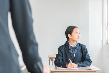 学校・予備校で模試・試験・受験・テストを受ける中学生・高校生・小学生の女の子（制服）

