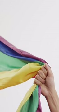 Vertical video of hand of caucasian man holding rainbow fabric